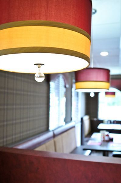 A restaurant with red and yellow lamps hanging from the ceiling