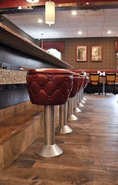 A row of red bar stools in a restaurant