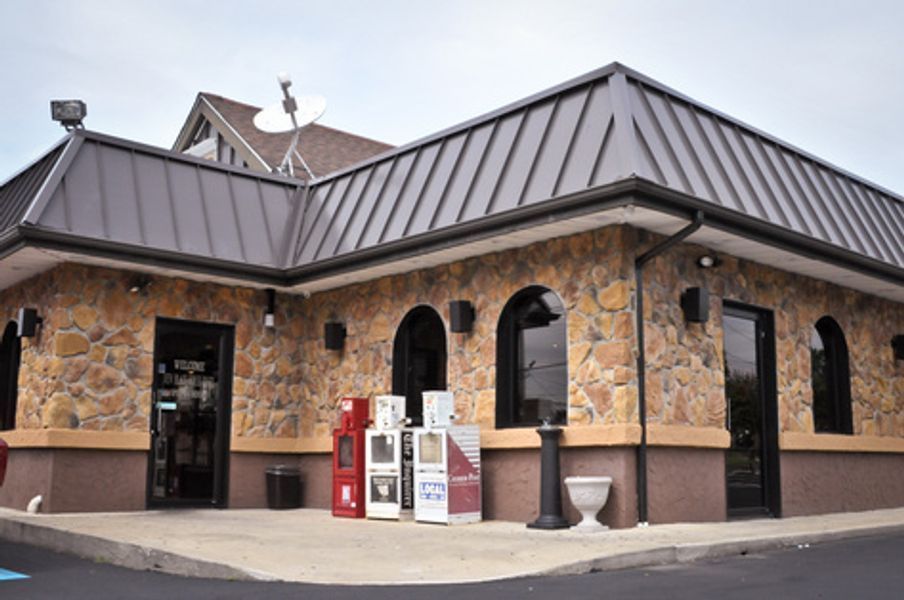 A building with a metal roof and a satellite dish on top of it