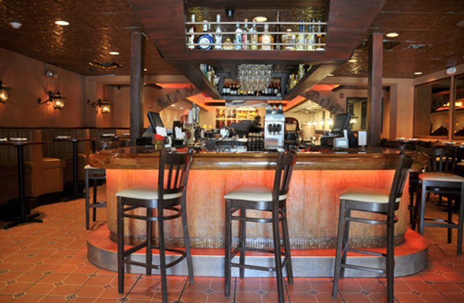 A restaurant with a bar and stools in front of it