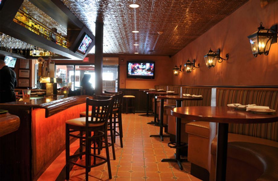 A restaurant with tables and chairs and a television on the wall
