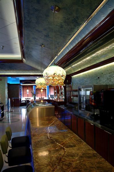 A restaurant with a marble counter top and a stainless steel sink