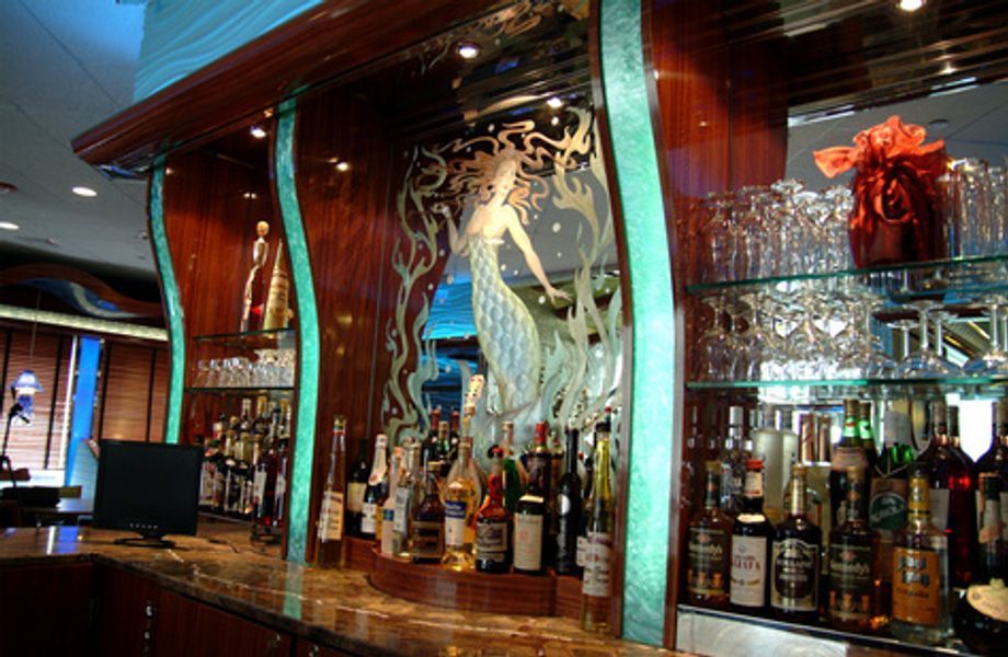 A bar with lots of bottles and glasses on it