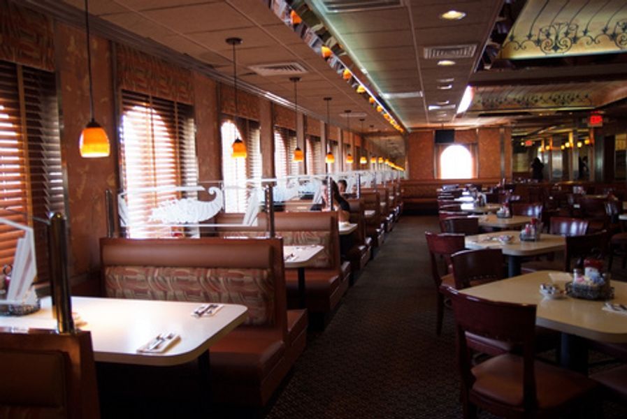 The inside of a restaurant with tables and booths