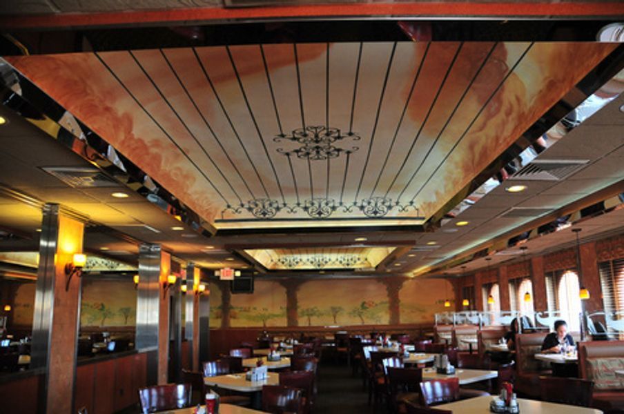 A restaurant with tables and chairs and a large ceiling