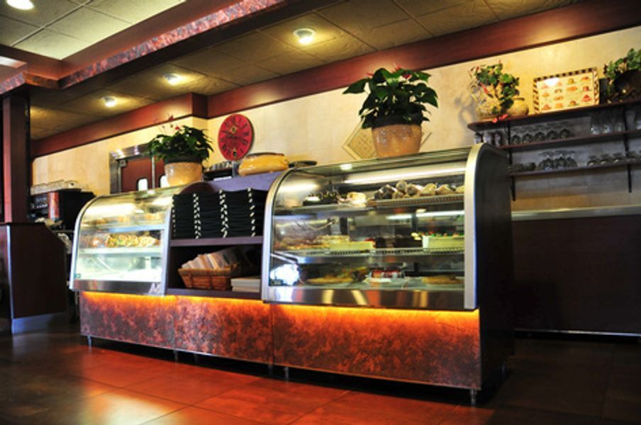 A display case in a restaurant with a clock on the wall