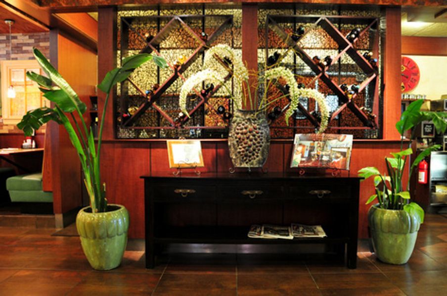 A dining room with a table and potted plants