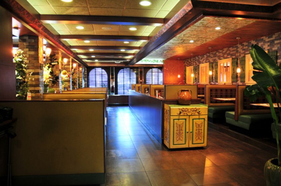 A long hallway in a restaurant with tables and chairs