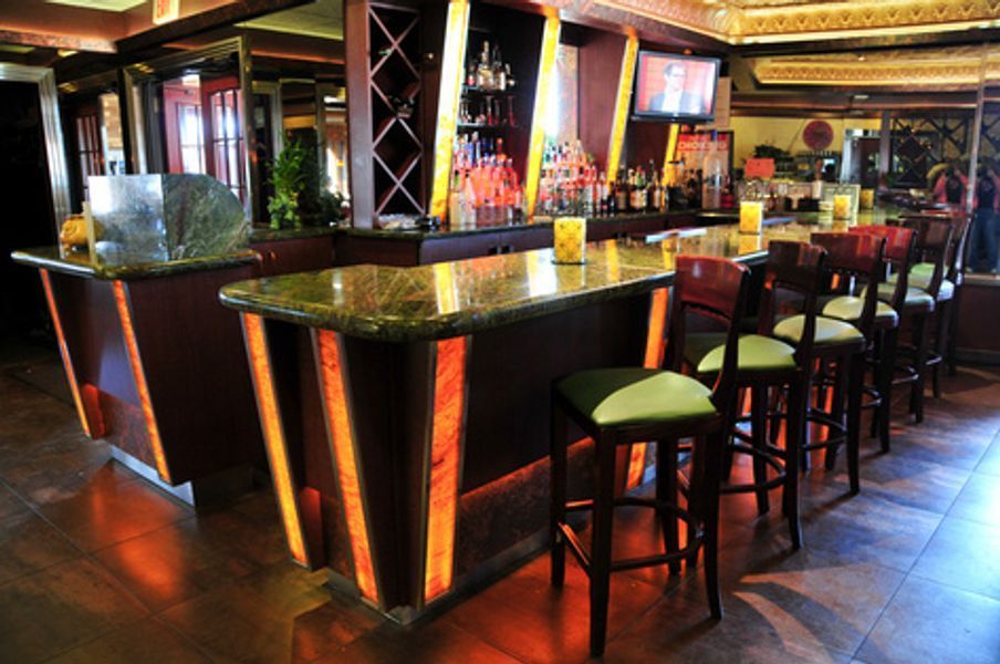 A row of bar stools are lined up in a restaurant