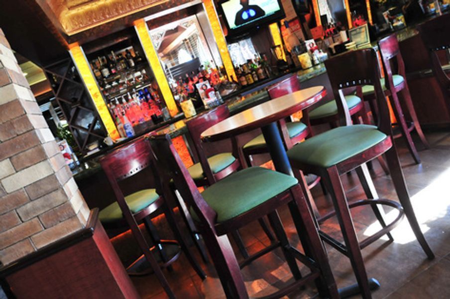 A bar with tables and chairs and a television
