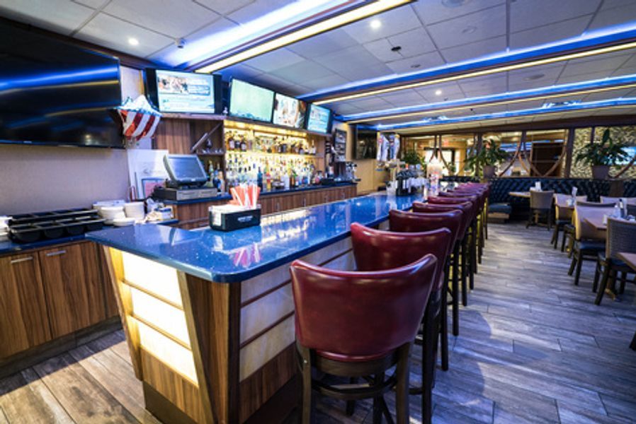 A restaurant with a long bar and a lot of chairs