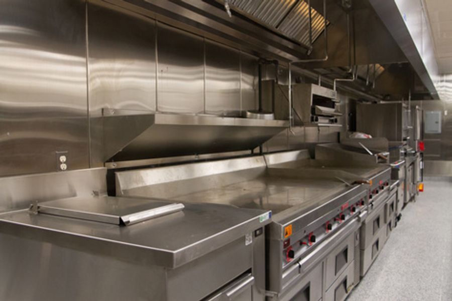 A kitchen with a lot of stainless steel appliances and counter tops