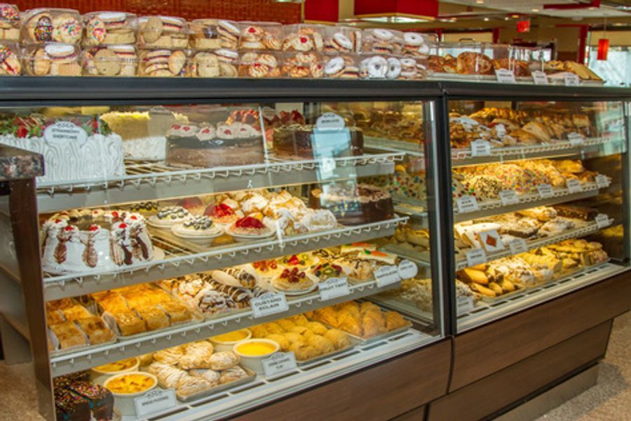 A bakery display case filled with a variety of pastries and cakes