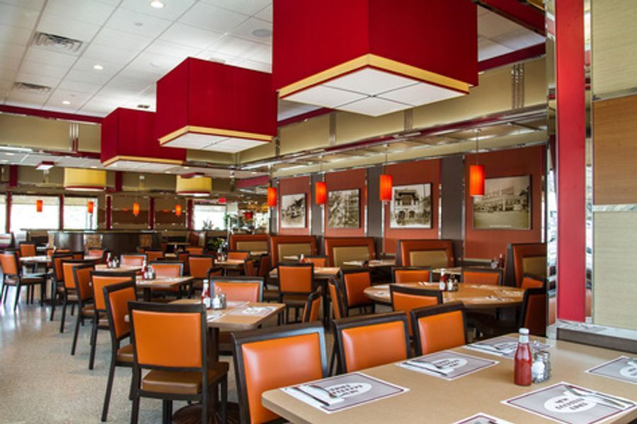 An empty diner with tables and chairs and red lights