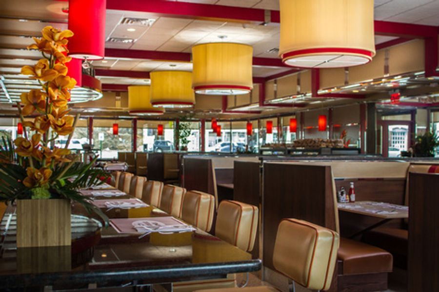 A diner with tables and chairs and a vase of flowers on the table