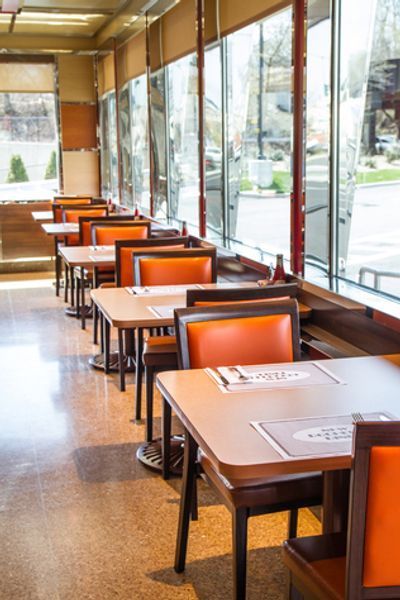 A restaurant with tables and chairs and a lot of windows