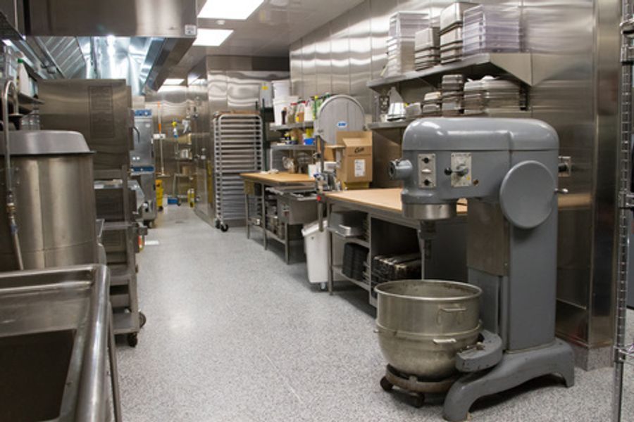 A large mixer is sitting in the middle of a kitchen