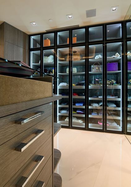A walk in closet with lots of shelves and drawers