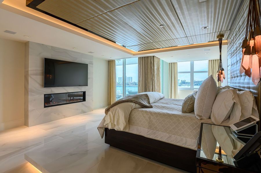 A bedroom with a large bed and a flat screen tv on the wall