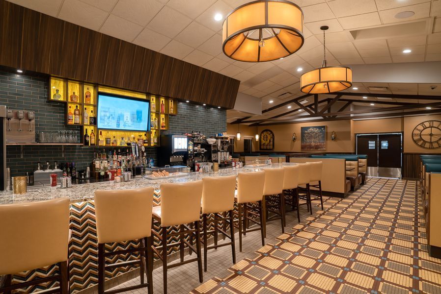 A restaurant with a long bar and lots of chairs