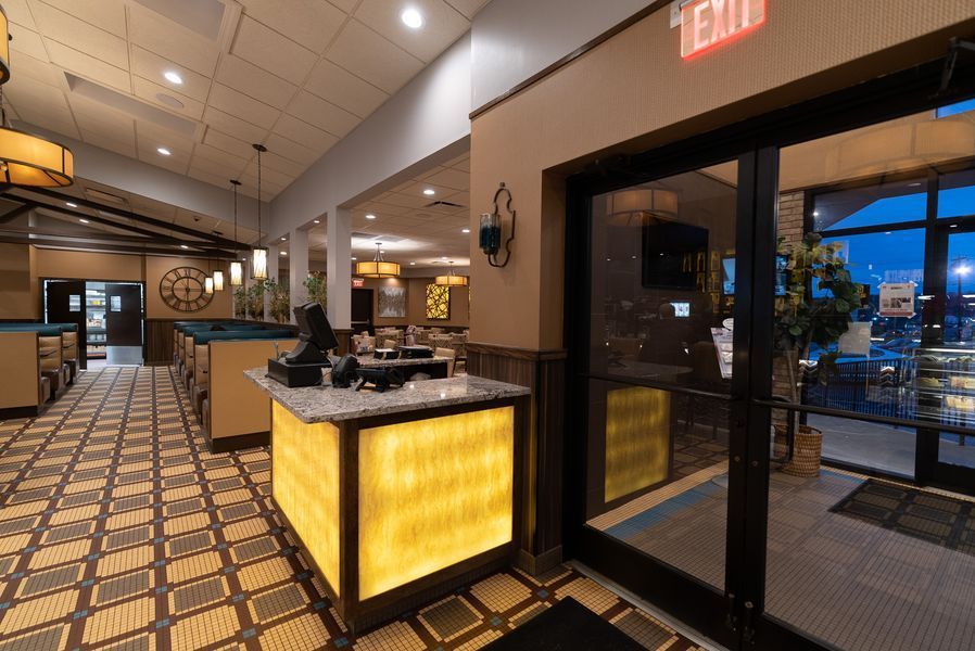 A restaurant with a yellow counter and a red exit sign