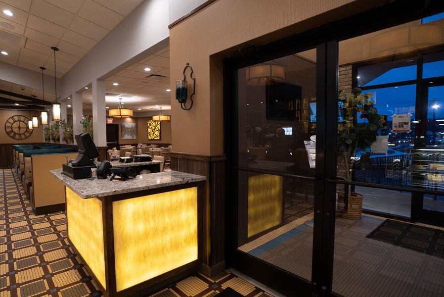 A restaurant with a large glass door and a counter in front of it