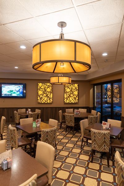 A restaurant with tables and chairs and a ceiling light
