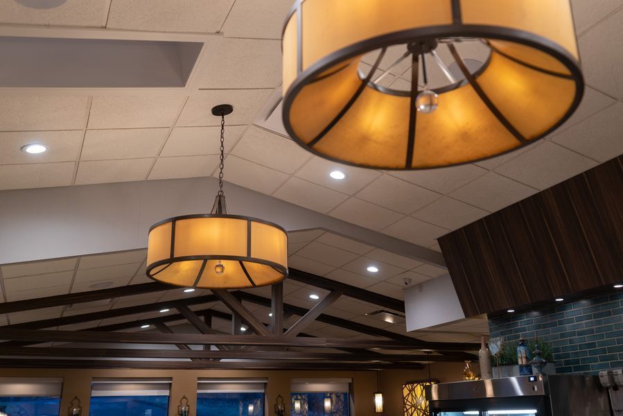 Two chandeliers are hanging from the ceiling of a restaurant
