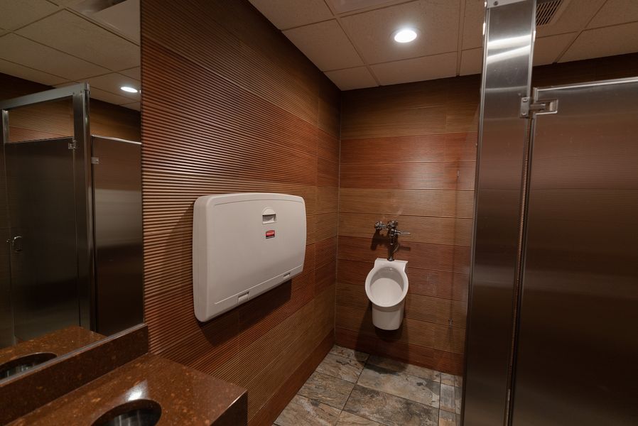 A bathroom with a urinal and a changing table