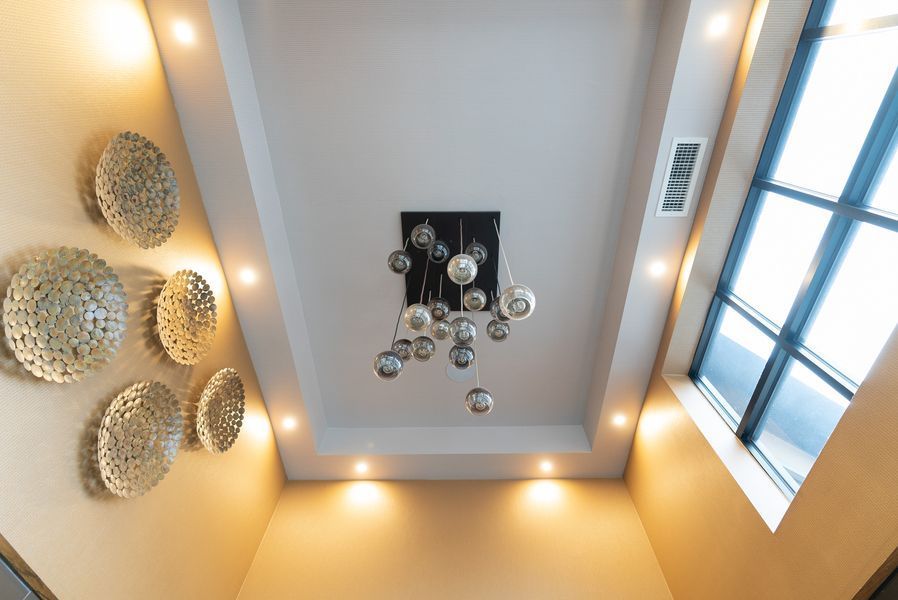 A ceiling with a chandelier hanging from it and a window