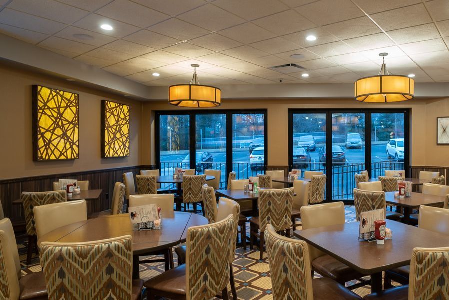 A large dining room with tables and chairs and a lot of windows