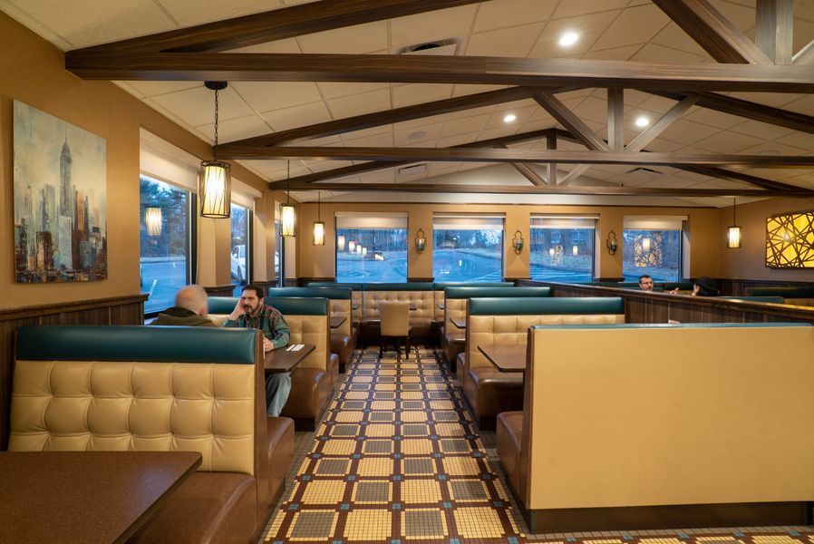 A man is sitting at a table in a diner