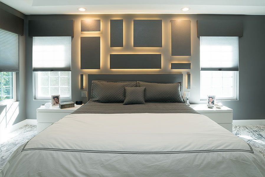A bedroom with a large bed and a gray wall