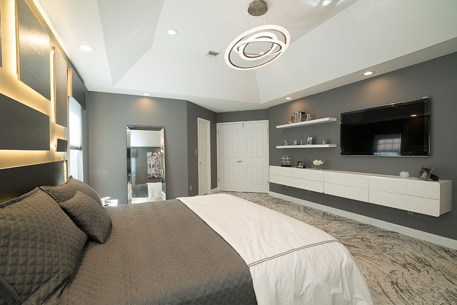A bedroom with a large bed and a flat screen tv on the wall