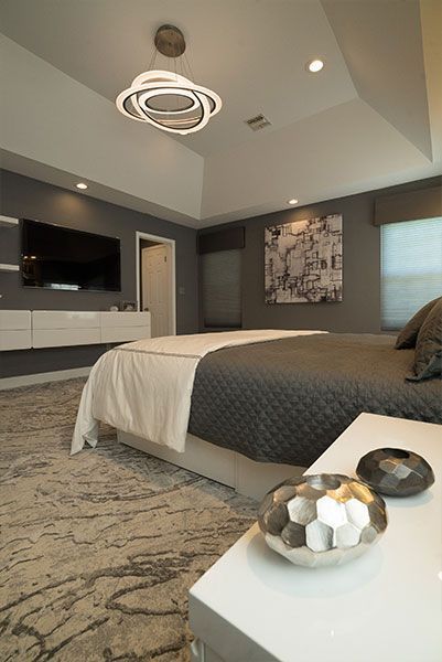 A bedroom with a large bed and a flat screen tv on the wall