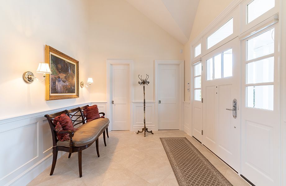 A hallway with a bench and a painting on the wall