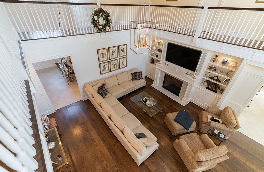 An aerial view of a living room with a large sectional couch and a fireplace