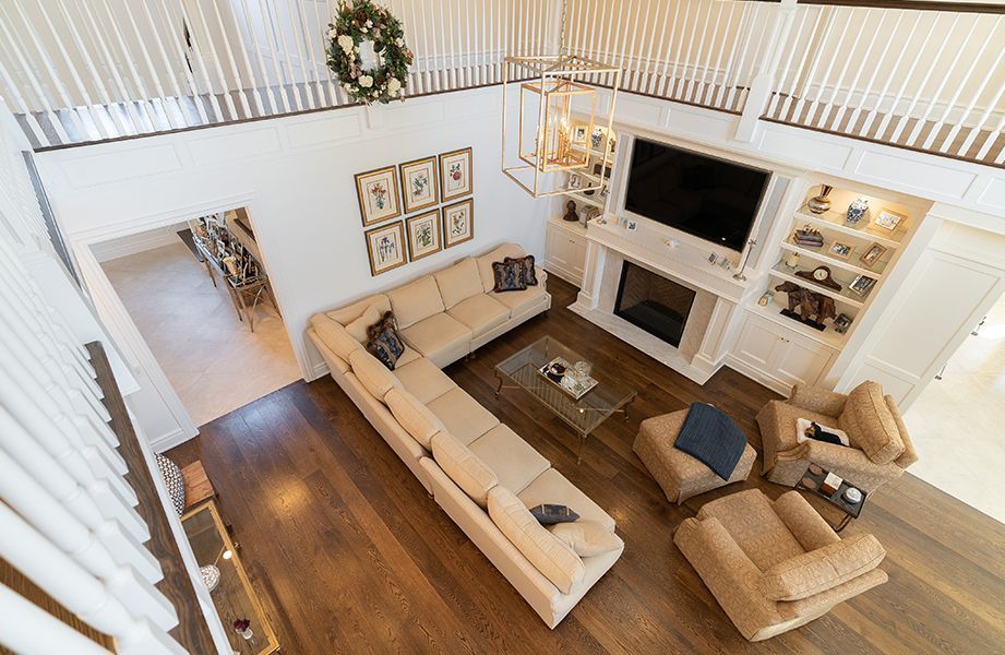 An aerial view of a living room with a couch, chairs, fireplace and television