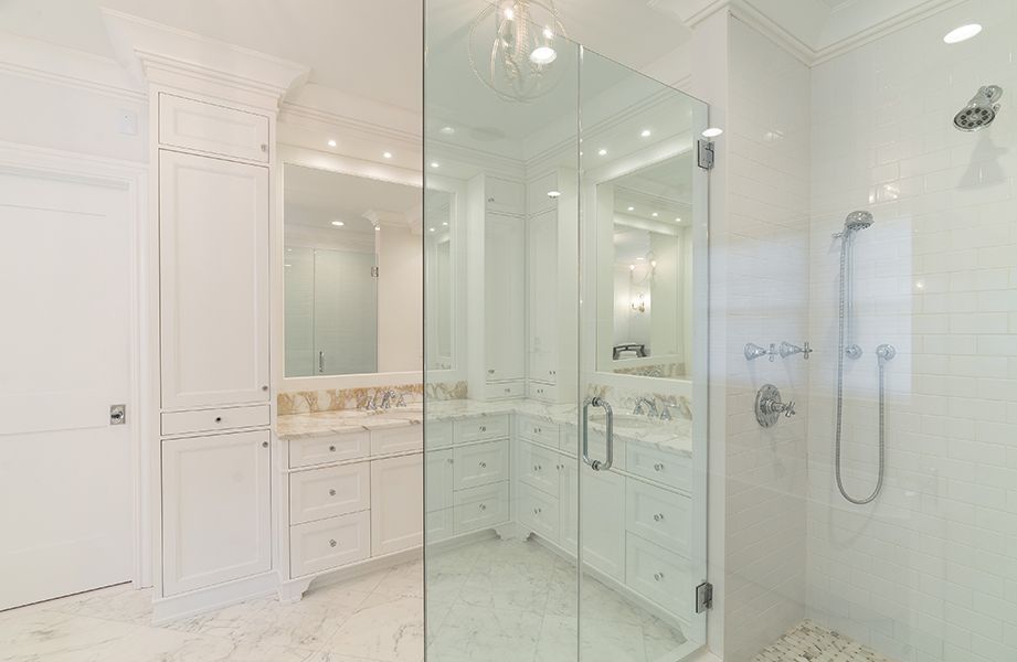 A bathroom with a walk in shower and two sinks
