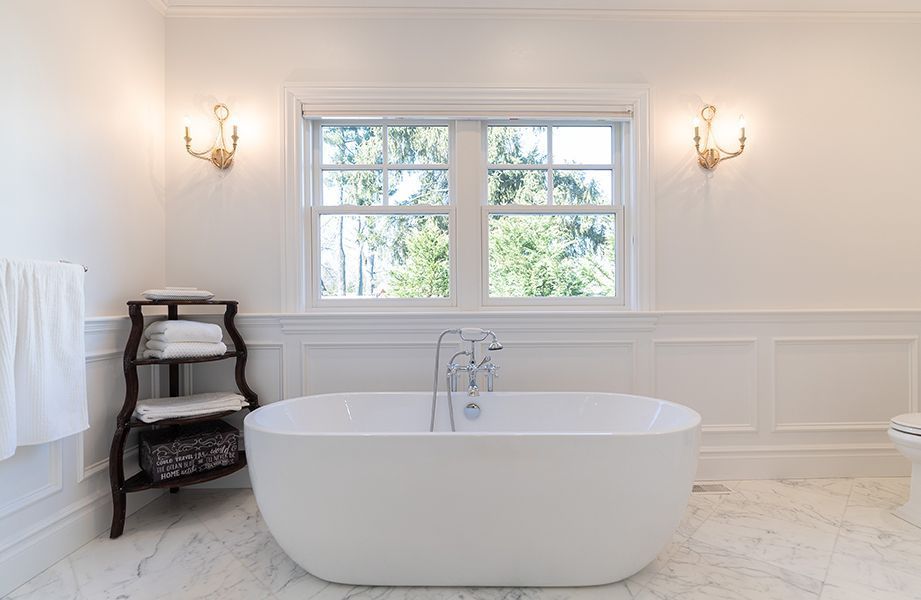 A bathroom with a bathtub and a window