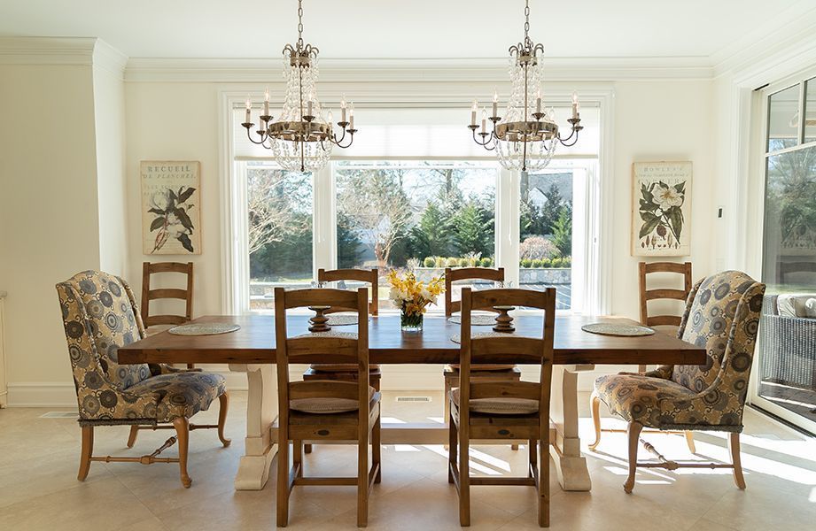 A dining room with a table and chairs and a large window