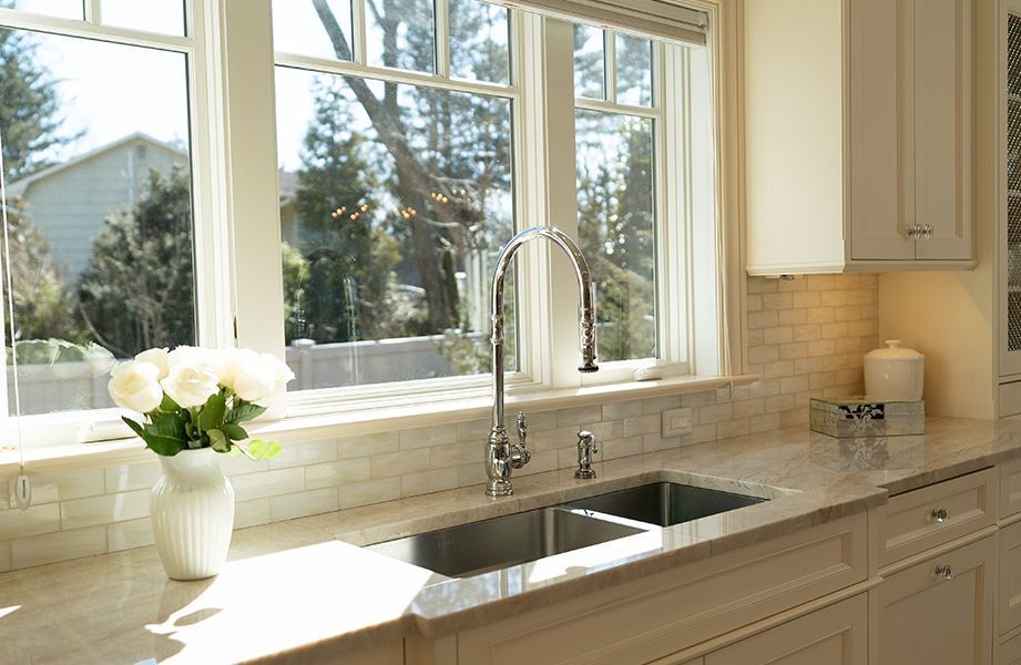 A kitchen with a sink and a vase of flowers on the counter