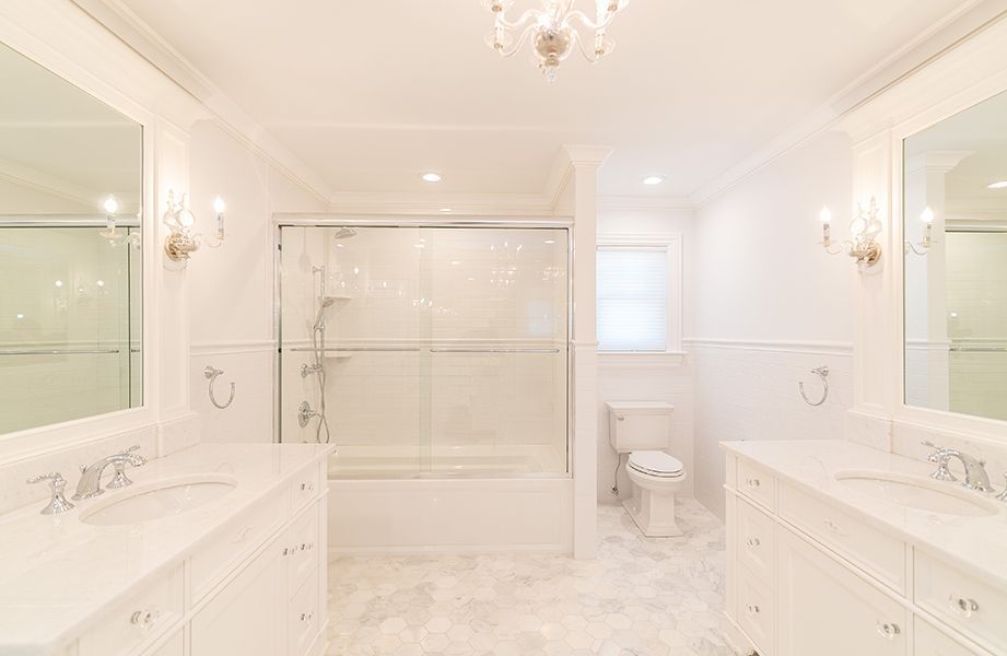 A bathroom with two sinks, a toilet, and a bathtub