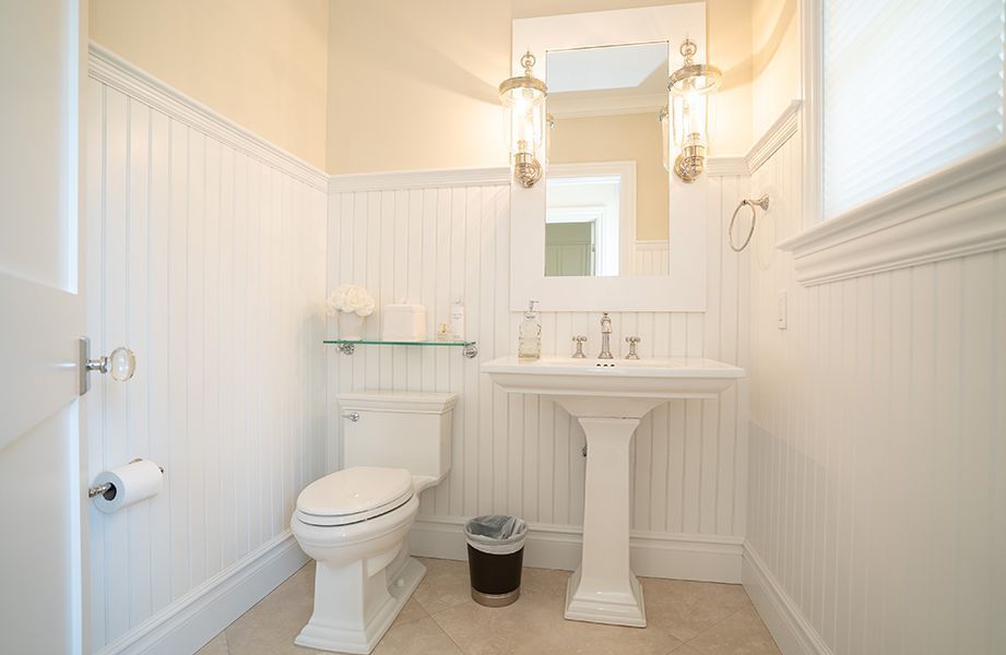 A bathroom with a toilet, sink and mirror