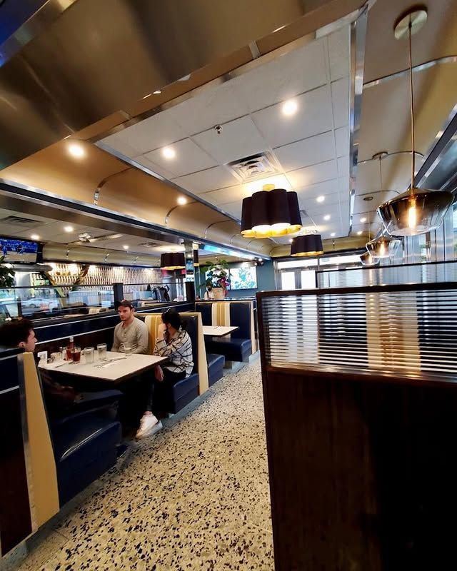 A diner with people sitting at tables and booths