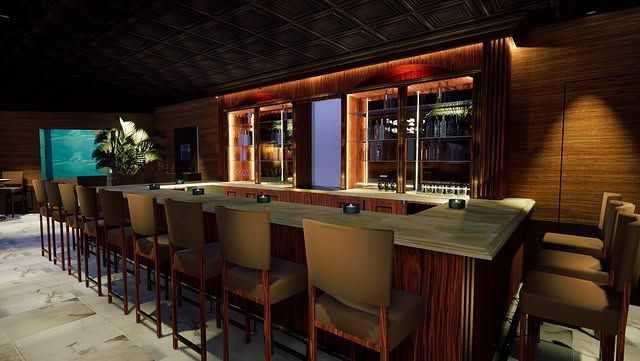 A bar with a long counter and chairs in a dark room.