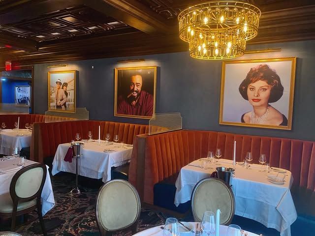 A restaurant with tables and chairs and paintings on the wall.