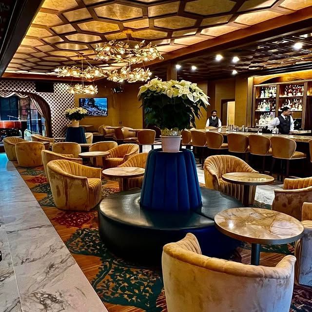 A restaurant with tables and chairs and a vase of flowers