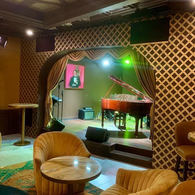 A room with a piano and chairs in it