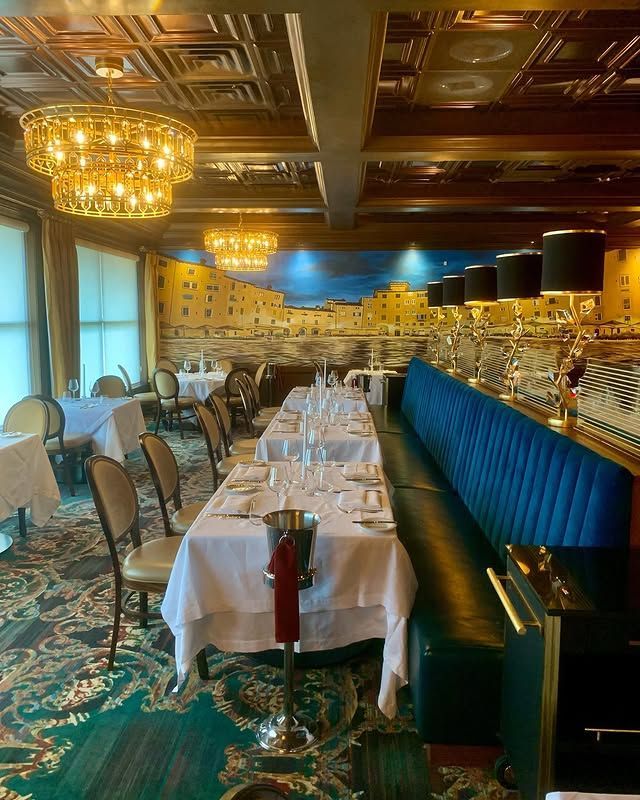 A large dining room with tables and chairs and a chandelier.